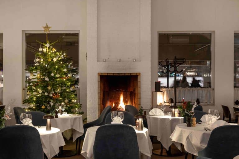 Mysig julbordsdukning med gran och tända ljus på Welcome Hotel