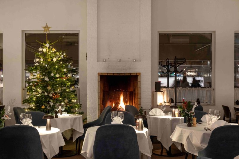 Mysig julbordsdukning med gran och tända ljus på Welcome Hotel